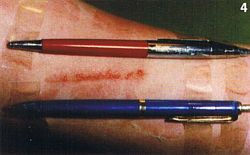 Ein roter und ein blauer Kuli sind auf dem Unterarm eines Patienten befestigt